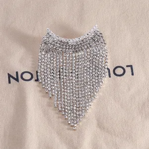 Broche élégante à franges argentées avec strass brillants et design en forme de V