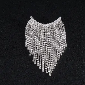 Détail d'une broche à franges en strass argentés avec pampilles scintillantes pour robes