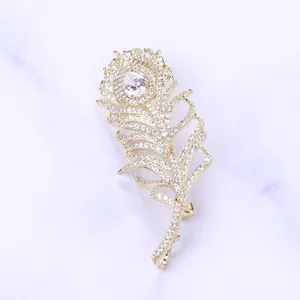 Détail macro de la broche plume dorée avec pierres de zircon et centre de taille poire