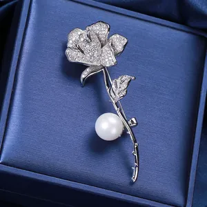 Elegante spilla a rosa d'argento con petali di zirconi e una grande perla bianca