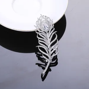 Détail macro de l'élégante broche plume argentée avec zircons et pierre en forme de poire