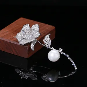 Dettaglio della spilla a rosa d'argento con zirconi micro-pave e una perla bianca