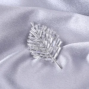 Dettaglio ravvicinato di una spilla a foglia d'argento con zirconi rettangolari micro-pave