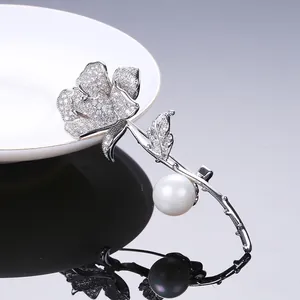 Dettaglio della spilla a rosa in argento con petali di zircone e una perla bianca tonda