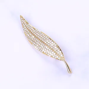 Macro shot of elegant gold leaf brooch featuring micro-pave sparkling cubic zirconia stones