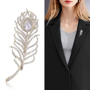 Broche élégante en plume de paon dorée sertie de zircons sur un blazer de costume