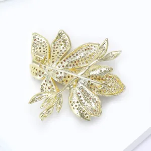 Detail showing back of gold floral brooch with pin closure and micro-pave rhinestones