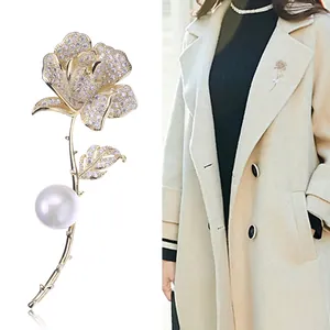 Elegante spilla a rosa con petali di zirconi e perla su stelo dorato lucido