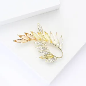 Detail of golden olive branch brooch with gradient yellow crystals and white zircons