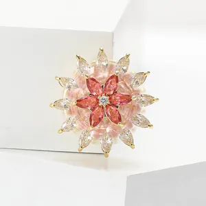 Détail de la broche flocon tournante en cuivre et zircon avec pierres marquises rouges