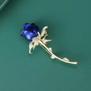 Macro shot of blue enamel rose brooch with gold plating and cubic zirconia inlay