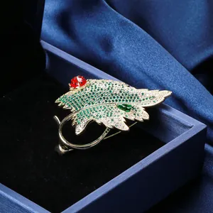 Détail macro d'une broche feuille avec cristaux verts et coccinelle en émail poli