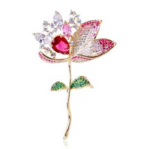 Close-up of gradient zircon lotus brooch with red pear-shaped stone and gold finish