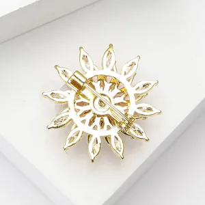 Vue macro du dos d'une broche flocon dorée montrant l'épingle et le fermoir de sécurité