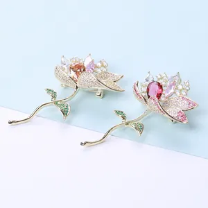Detailed close-up of lotus brooches with gradient crystals and pear-cut center stones