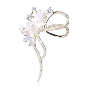 Details einer eleganten Schleifenbrosche mit Muschelblüten, Vergoldung und Zirkonia