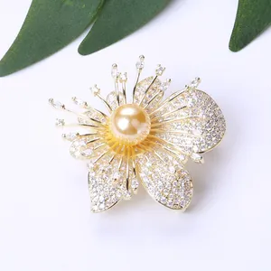 Dettaglio di una spilla a orchidea di lusso con zirconi e una perla dorata centrale