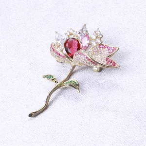 Macro detail of luxury lotus brooch featuring red teardrop stone and pink pavé crystals