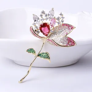 Macro detail of luxury lotus brooch with red drop zircon and gold flower petals