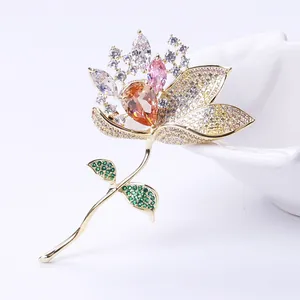 Macro shot of luxury lotus brooch with orange zircon center and yellow pavé petals