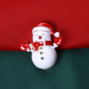 Broche bonhomme de neige de Noël avec strass colorés sur fond festif rouge et vert