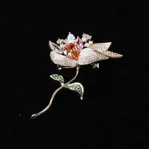 Detailed close-up of a floral brooch with orange drop-shaped stone and micro zircon inlay