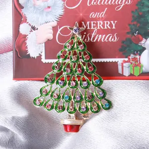 Green enamel Christmas tree brooch with colorful rhinestones on festive gift box