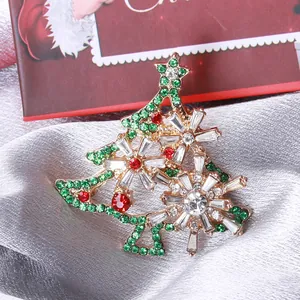 Sparkling Christmas tree brooch with colorful rhinestones on elegant silk fabric background