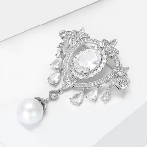Detail of baroque brooch with clear zircon drop charms and a large white pearl hanging