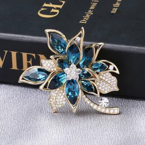 Macro shot of luxury flower brooch with navy blue crystals and zircons on a book
