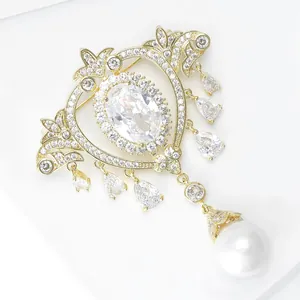 Detailed macro of Baroque pearl brooch with gold metal lace and zircon crystal tassels