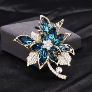 Macro detail of high-end floral brooch with deep blue marquise crystals and zircons