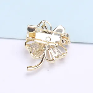 Detail view of the gold-plated four-leaf clover brooch back with safety pin clasp