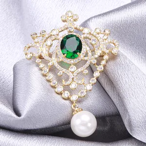 Vintage gold medal brooch with green gemstone, cubic zirconia and pearl on silver silk