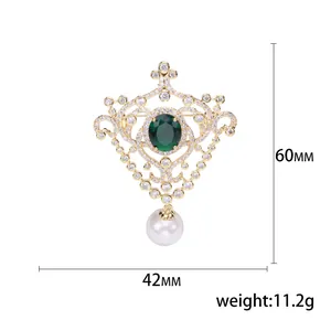 Baroque style brooch with green gemstone, white crystals and a pearl drop ornament