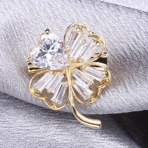 Elegant four-leaf clover brooch with gold metal and faceted cubic zirconia stones
