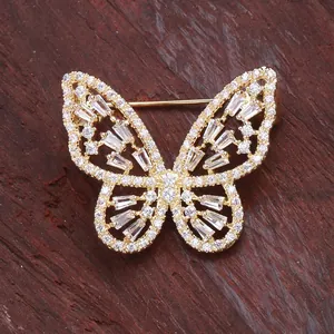 Élégante broche papillon dorée avec diamants pavés sur un fond en bois rustique