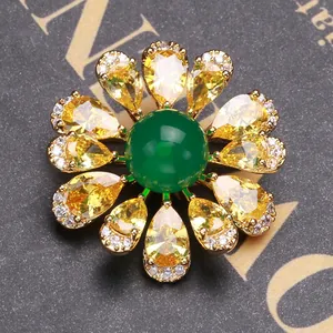 Elegant floral brooch with emerald green gem and yellow zircon petals in gold finish
