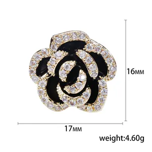 Elegant camellia brooch with black enamel, white zircons, and gold metal plating