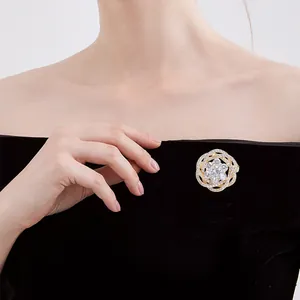 Vue détaillée d'une broche fleur dorée avec zircons blancs sur un costume en velours noir