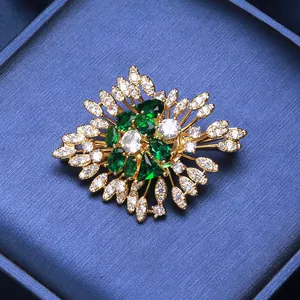 Luxury emerald zircon brooch with gold plating on deep blue velvet jewelry box