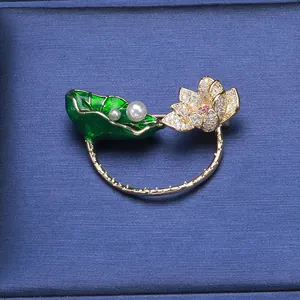 Broche lotus élégante avec feuille en émail vert et perles blanches sur boîte à bijoux
