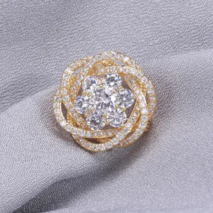 Détail de la broche fleur dorée aux pétales superposés sertis de zircons étincelants