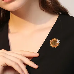 Elegante broche de girasol esmaltado con detalle de abeja de circón en un cárdigan negro