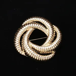 Macro detail of golden triple-intertwined knot brooch with fine horizontal textures