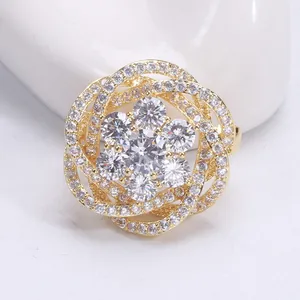 Détail macro d'une élégante broche fleur plaquée or avec zircons et pétales évidés