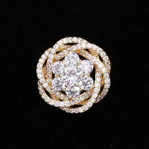 Vue macro détaillée d'une broche fleur dorée sertie de zircons sur velours noir élégant