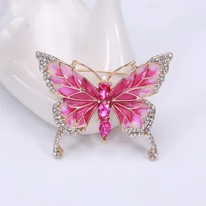 Detailed close-up of pink and white enamel butterfly brooch with sparkling crystals