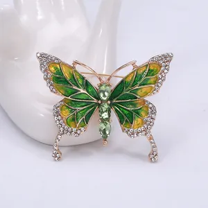 Detailed shot of green enamel butterfly brooch with gold plating and sparkling rhinestones