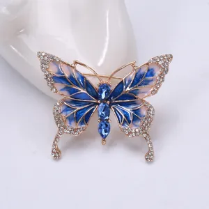 Macro detail of enamel butterfly brooch with blue crystals and diamond-encrusted wings